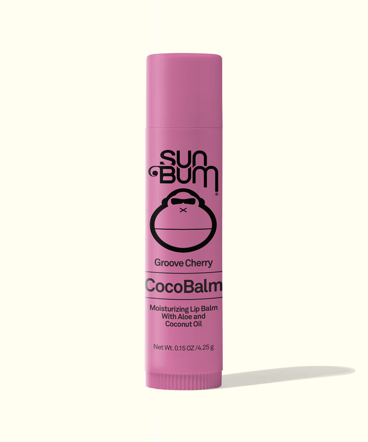Pink tube of Groove Cherry CocoBalm Lip Balm, known as the world's greatest lip balm, featuring a moisturizing formula with aloe and coconut oil. Sun Bum
