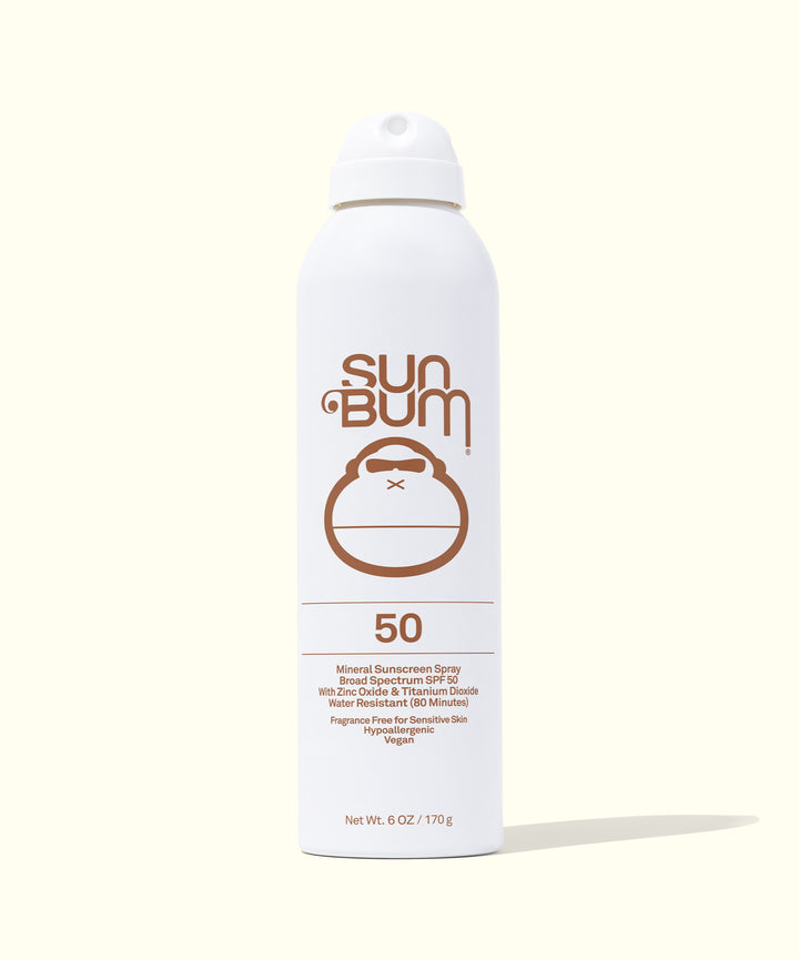 Mineral SPF 50 Sunscreen Spray in white can with brown Sun Bum logo, featuring a zinc-based, fragrance-free formula and non-aerosol compression system for broad-spectrum protection. Sun Bum.