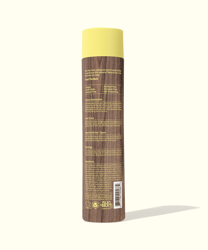 Brown bottle of Revitalizing Shampoo with yellow cap, featuring hydrating ingredients like Coconut Oil, Banana, and Sunflower Seed Oil. Sun Bum.