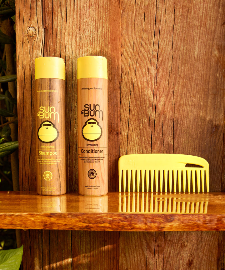 Yellow Wide Tooth Conditioning Comb displayed alongside Sun Bum shampoo and conditioner bottles on wooden shelf, perfect for detangling wet or dry hair - by Sun Bum