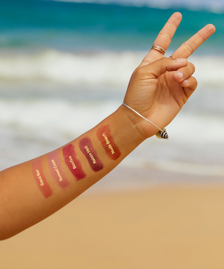 Arm showcasing different shades of Tinted SPF 15 Lip Balm at the beach, Sun Bum,